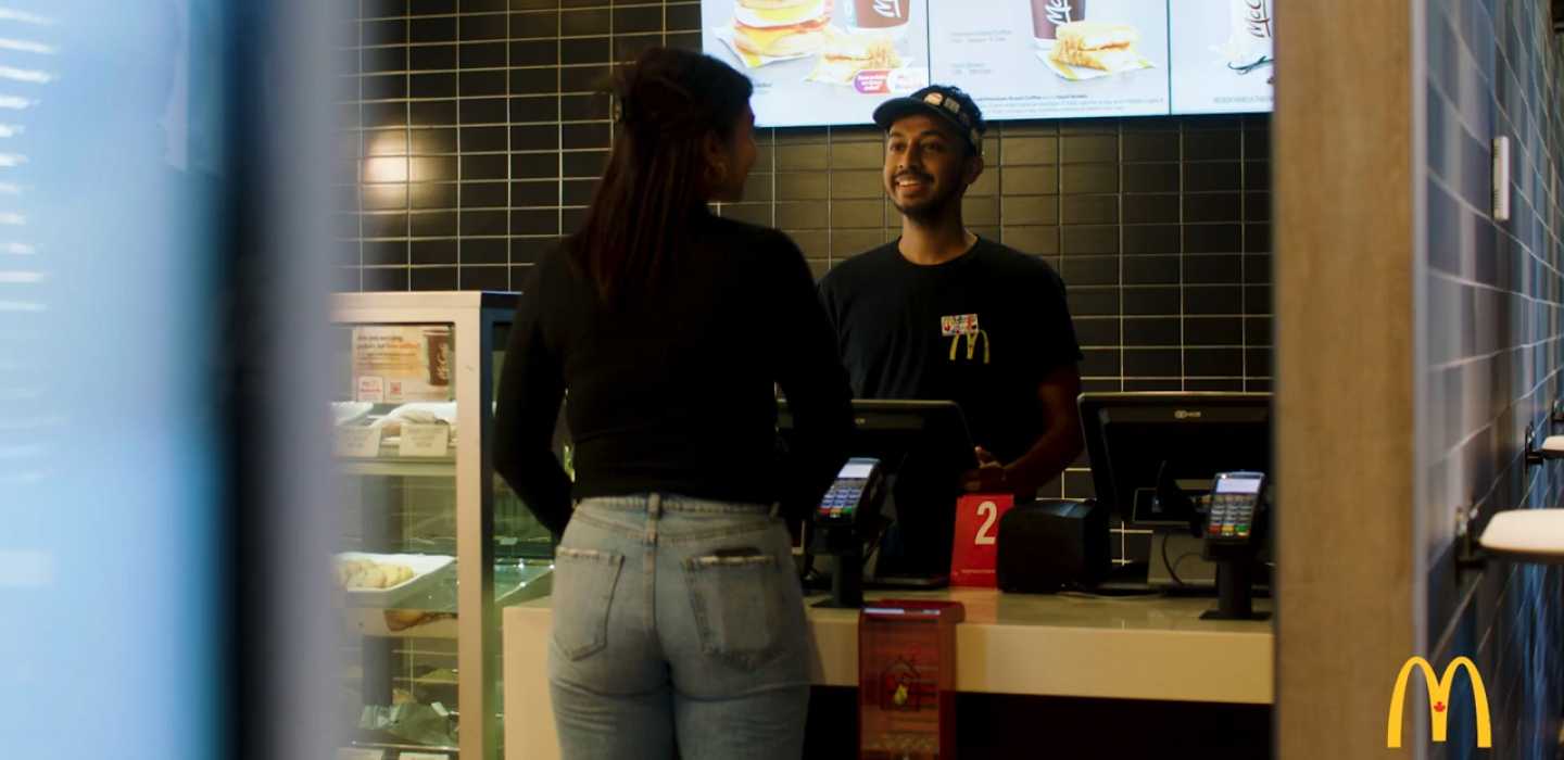 a employee taking a customers order at the counter of a McDonalds restaurant