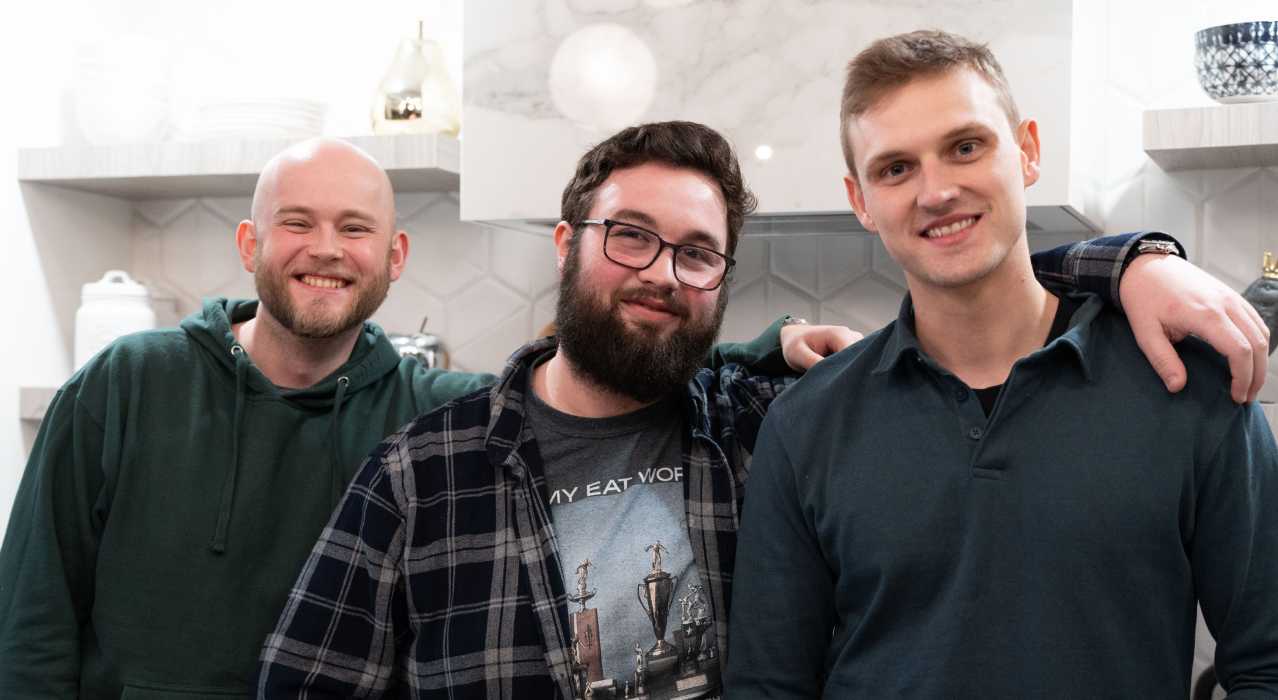 Three male co-worker posing for a photo at a company event