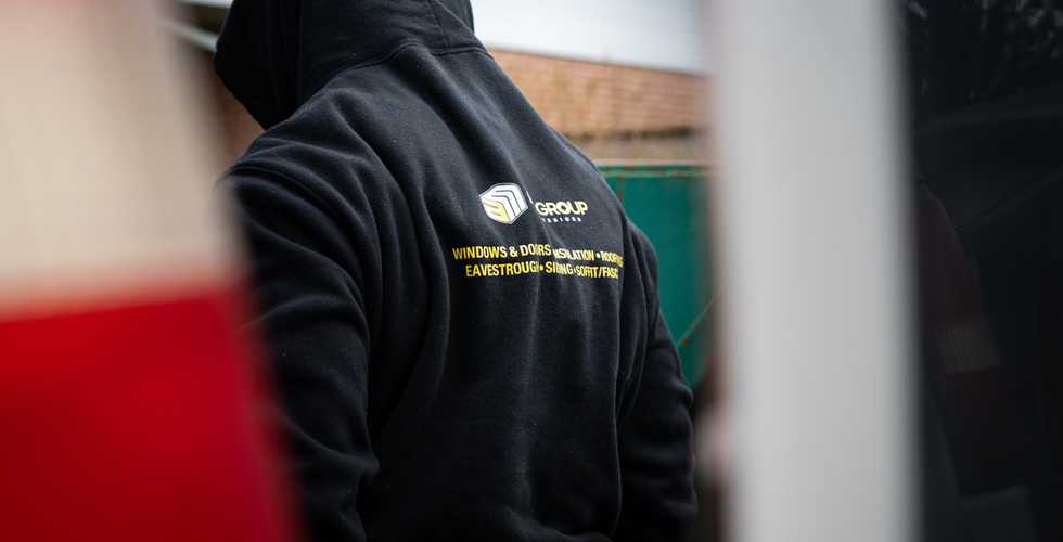 the back of a AMGroup Exterior employee wearing a company sweater